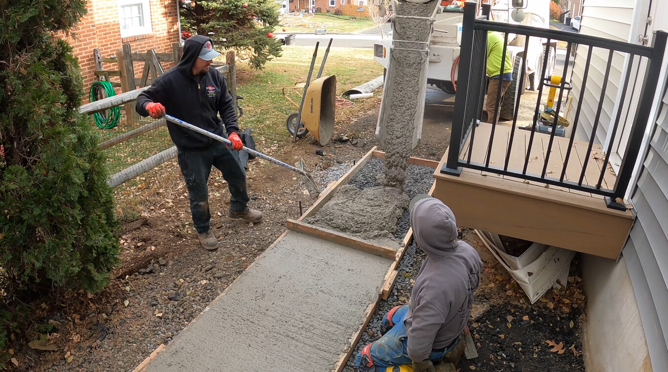 Workers installing concrete sidewalk with precision in Redwood City